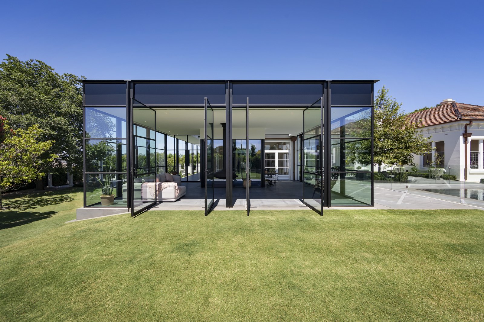 Black-framed aluminium glazing and pivot doors on a modern home