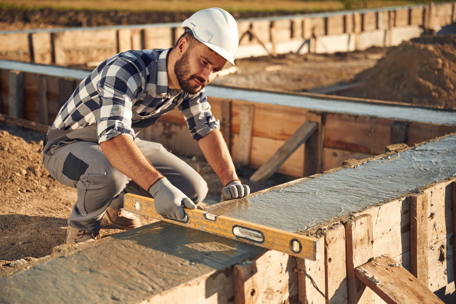 MGP worker levelling a reinforced concrete house foundation on site